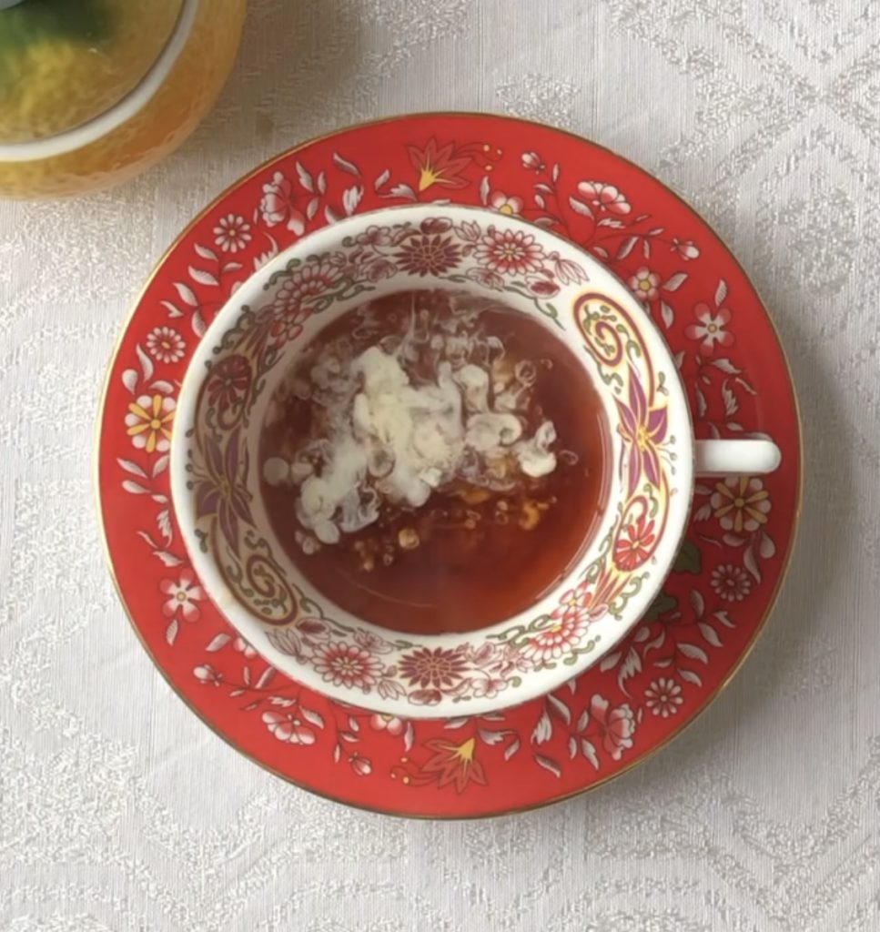 Red and white wedgwood cup and saucer full of clouds and "fireworks" from East Frisian tea with cream