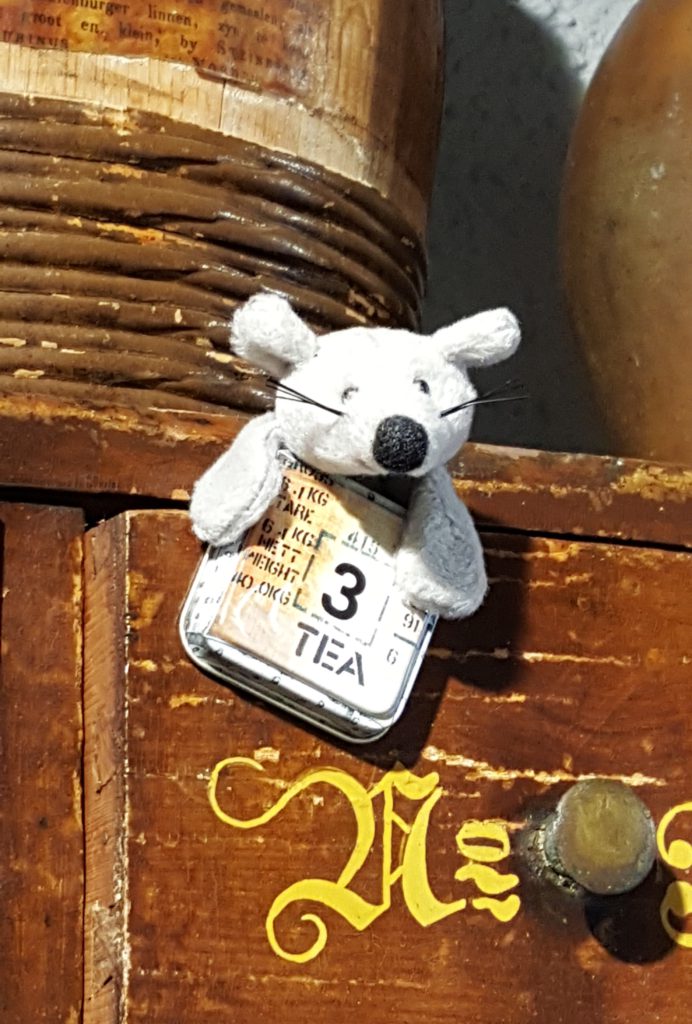 Photo of Tippi the Tea Mouse stuffed animal peeking out of a tea tin