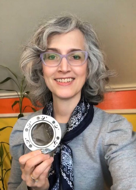 Traci Levy, AKA Tea Infusiast, holding a basket tea infuser and smiling