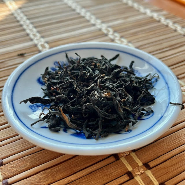 Guan Yin Hong tea leaves in a white dish.