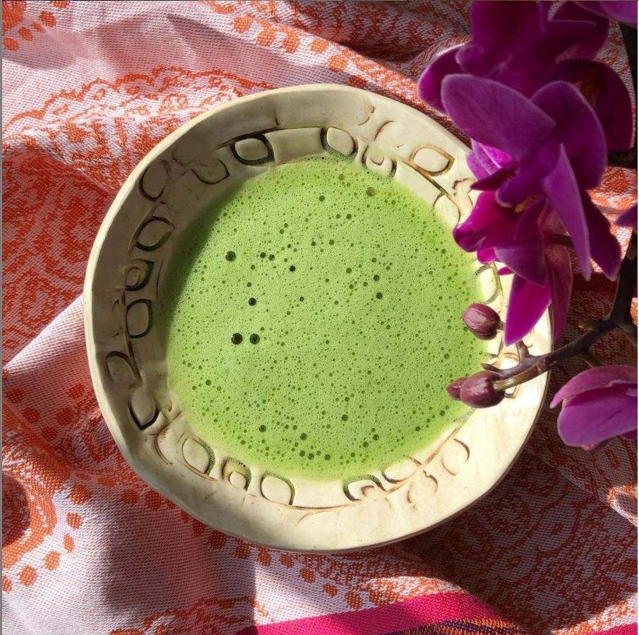 Bowl of frothy green Kiwami matcha with orchids on the side