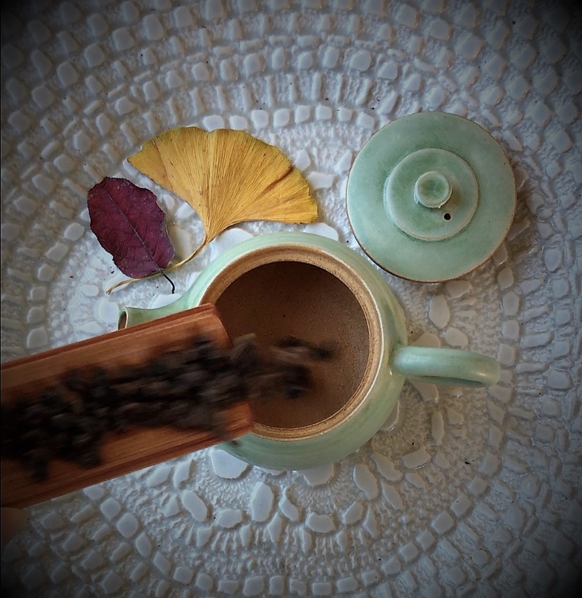 This image shows an image of tea sliding down a tea scoop into a teapot that might evoke the tea soundscape for some viewers.