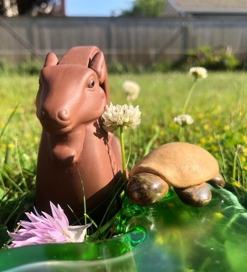 Two clay tea pets, Rocco the ram (friend of @teainfusiast) and Herb the Traveling Tea Turtle, sunbathing outside