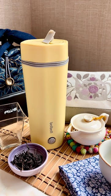 balboni portable electric kettle on a bamboo matt next to tea and tea accessories