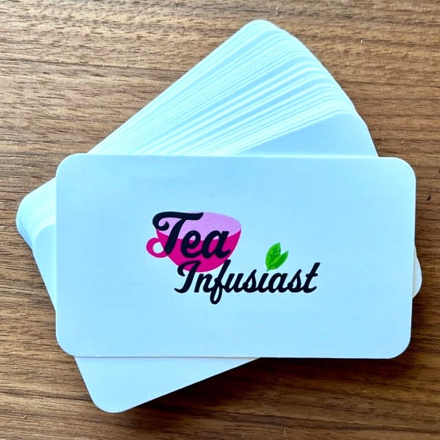 A stack of white business cards with the Tea Infusiast logo