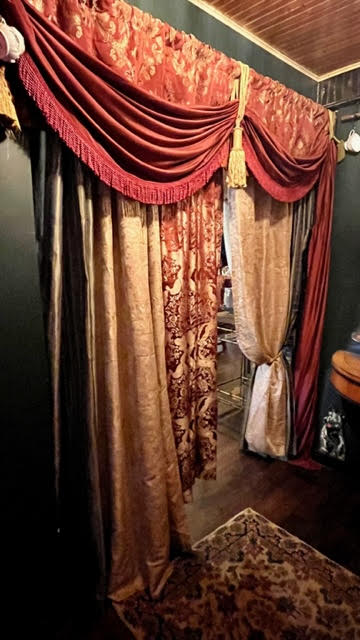 Dramatic gold and crimson drapery separating the foyer from the first room at The Parlour.