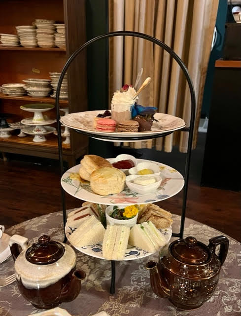 Three-tiered tray full of tea sandwiches, scones, and desserts at The Parlour