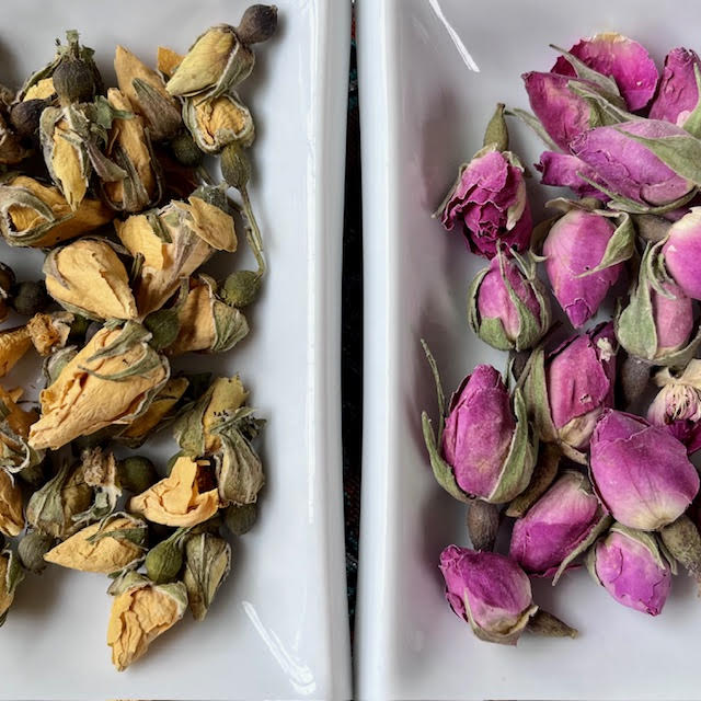 A dish of yellow rosebuds and a dish of pink rosebuds