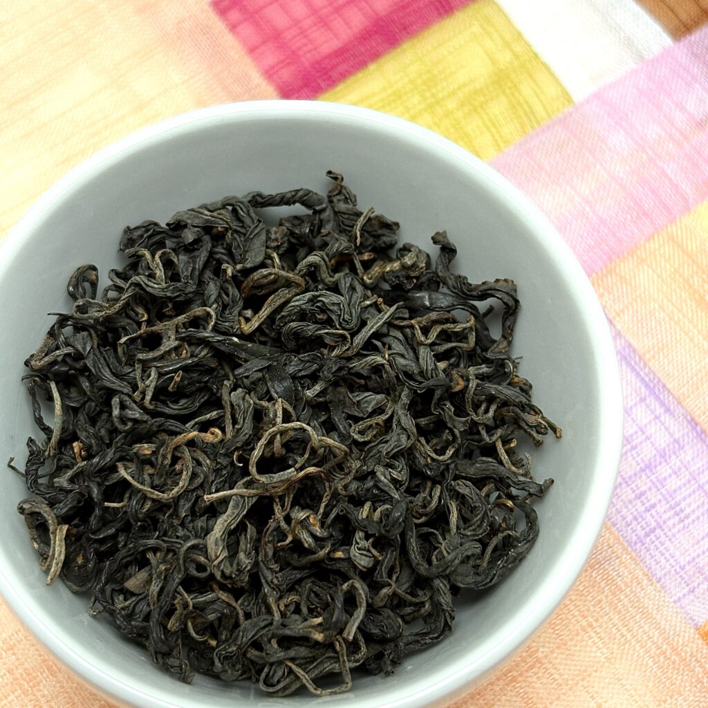 Twisted, loopy, and delightful Hwangcha tea leaves from Soocha Tea next to a traditional Korean patchwork coaster