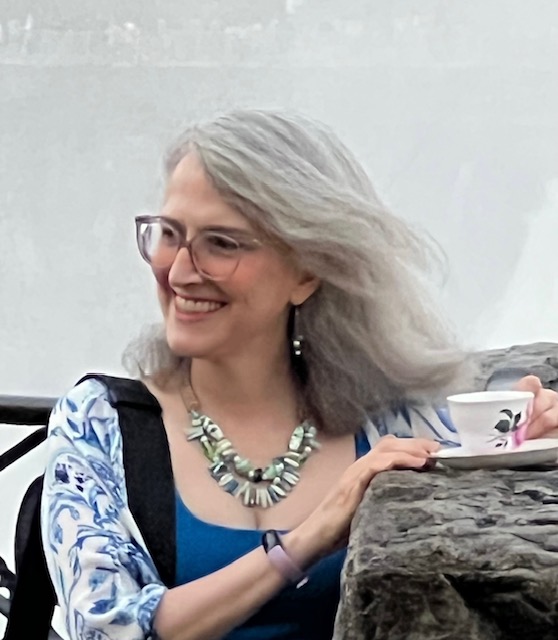 Traci Levy a.k.a. Tea Infusiast holding a teacup in the blowing wind by the Horseshoe Falls in Niagara Falls, Canada.