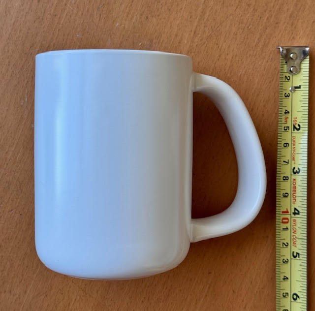 white ceramic mug by CURVD showing measuring tape measuring the height