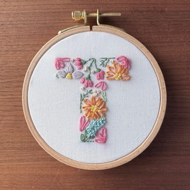 Colorful embroidered letter "T," to symbolize our monthly event for TIN subscribers, the CrafTEA Social