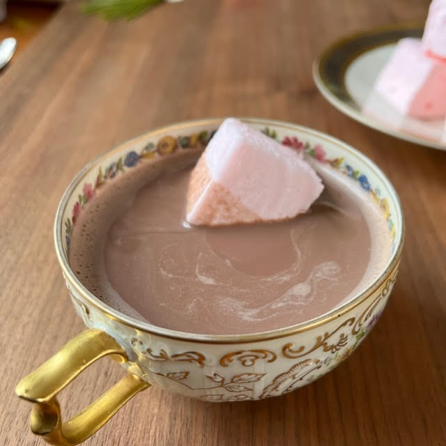 favorite hot cocoa with a pink marshmallow in a floral teacup with a gold handle