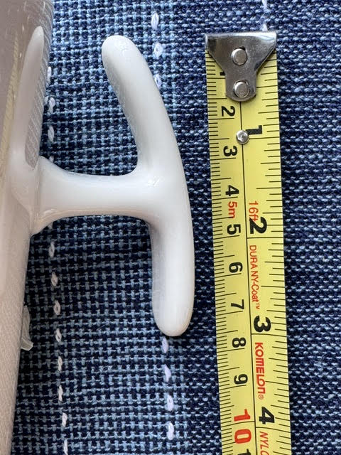 Close up of T-shaped handle (T Handle) mug's handle next to a yellow measuring tape showing the length of the handle.