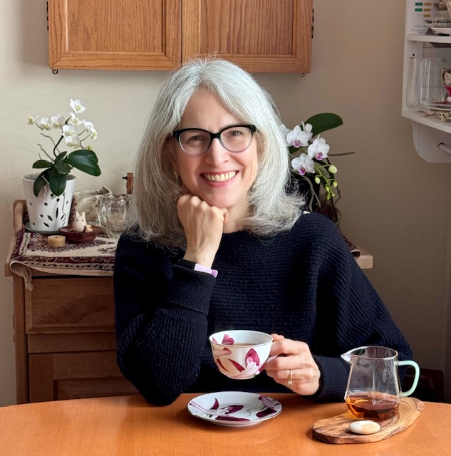 Traci aka Tea Infusiast holding a teacup in her kitchen Jan 2026